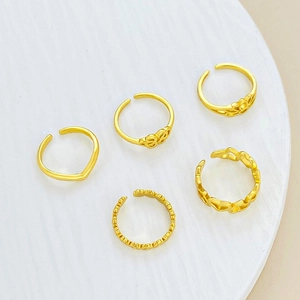 Detalle de 5 anillos ajustables dorados para el pie con diseños florales huecos y ondas