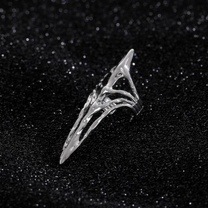 Detailed close-up of a silver gothic skeleton claw ring with a hollow design on black surface