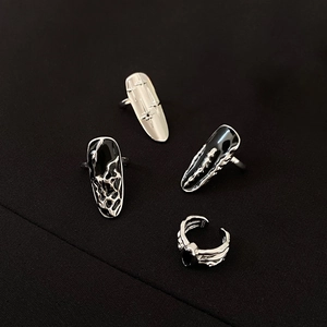 Detail of gothic silver nail rings with black enamel drips and sparkling star engravings