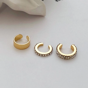 Macro detail of 3-piece gold ear cuff set featuring zircon micro-inlay and minimalist matte finish