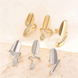 Detailed view of geometric rhinestone nail rings in gold and silver on stone