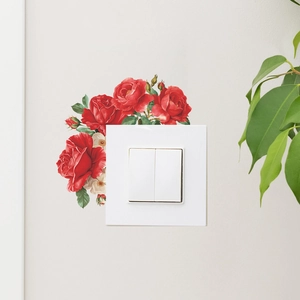 Self-adhesive red rose wall sticker decorating a white light switch in a cozy bedroom