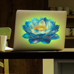 Glow-in-the-dark lotus flower sticker on a laptop with luminous green edges