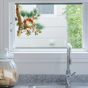 Colorful squirrel wall sticker on kitchen window with pine cones and branches