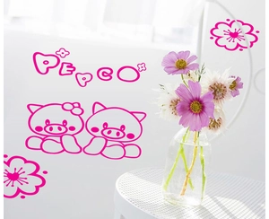 Detail of pink cartoon pig wall stickers with floral motifs on a clean white wall