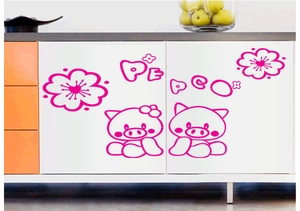 Detail of pink cartoon pig wall stickers with PEPCO letters on a white cabinet surface