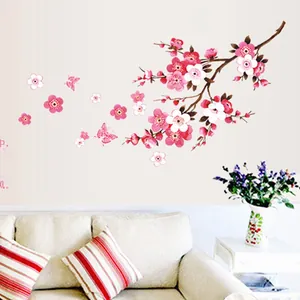 Detail of pink plum blossom wall sticker with butterflies in a cozy living room setup