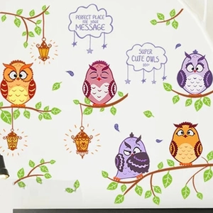 Detail view of colorful cartoon owls, tree branches and message clouds on wall stickers
