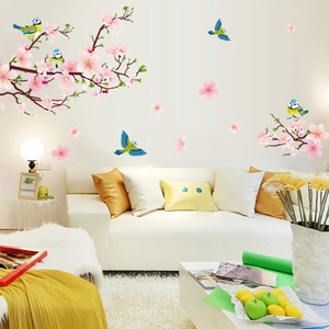 Détail de stickers muraux fleurs de pêcher et pie dans un salon chaleureux
