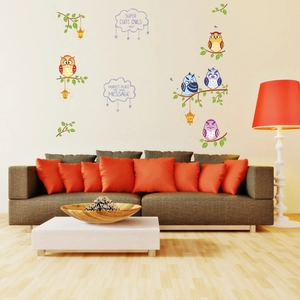 Detail of colorful cartoon owl wall stickers on branch in a modern nursery room