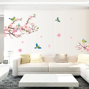 Détail d'autocollant mural de fleurs de pêcher roses et oiseaux dans un salon moderne