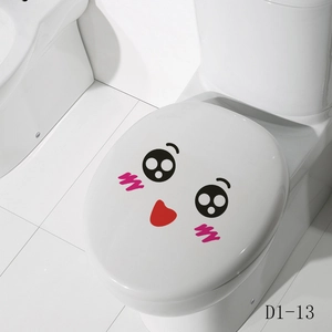 Close-up of cute cartoon face decal with pink cheeks on a white ceramic toilet lid