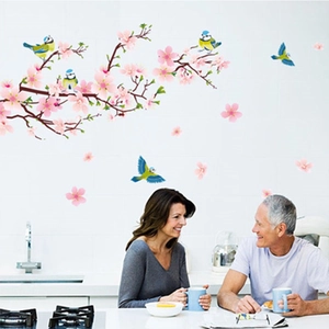 Detailed view of pink cherry blossom wall decals with blue birds in a modern kitchen