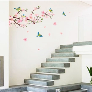 Detail view of pink cherry blossoms and colorful birds wall decals on a staircase wall