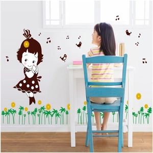 Detail of cartoon girl and sunflower wall decals in a bright nursery setting