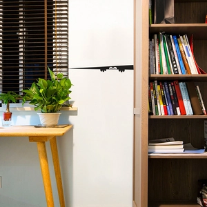 Funny peeping eye silhouette wall decal applied on a clean white wall in a study room