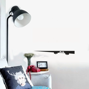Funny peeking monster wall sticker design showing the black vinyl silhouette in a living room