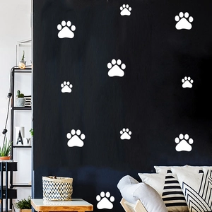 Detail of white paw print wall stickers on a dark wall in a modern living room