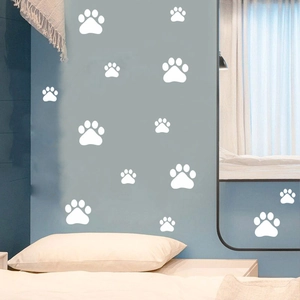 Detail showing white cartoon paw print stickers applied on a blue bedroom wall surface