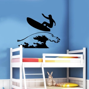 Black vinyl surfing silhouette wall decal showing a surfer riding waves in a boy's bedroom