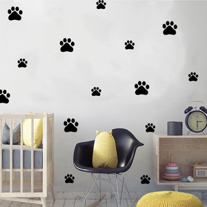 Nursery wall decor with black cartoon dog paw print stickers and baby room furniture