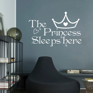 Sticker mural blanc Princess Sleeps Here avec couronne et cœur sur mur bleu foncé