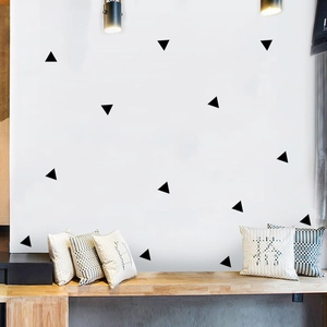 Detail showing black geometric triangle wall stickers on a clean white bedroom wall decor