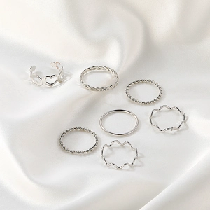7-piece vintage silver geometric ring set with heart and twist designs on white silk