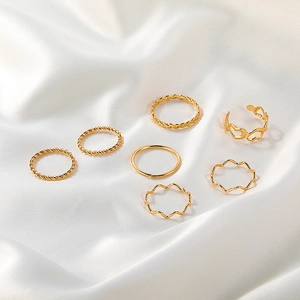 Vintage 7pcs gold alloy ring set with twist and heart shapes on white silk
