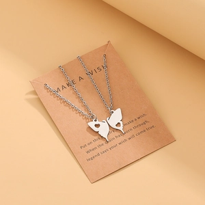 Detailed view of stainless steel butterfly friendship necklaces on a kraft gift card