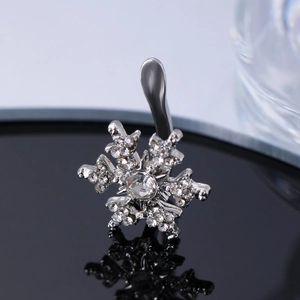 Detalle macro del piercing de ombligo de copo de nieve plateado con circonitas brillantes