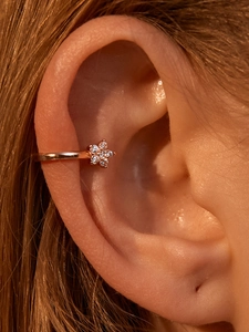 Detalle del ear cuff de flor en oro rosa con cristales de circonita brillantes