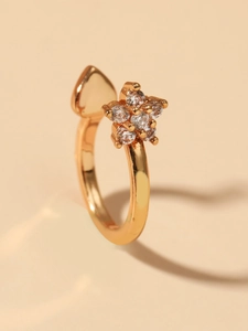 Macro shot of gold snowflake ear cuff with heart motif and cubic zirconia stones