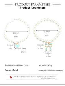Detail of beaded bracelets with heart and bow charms in gold finish and light blue tones