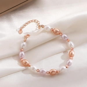 Detail of multi-colored pearl bracelet with rose gold beads and heart charm