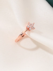 Foto macro de anillo estrella oro rosa con piedras de circonita blanca brillante