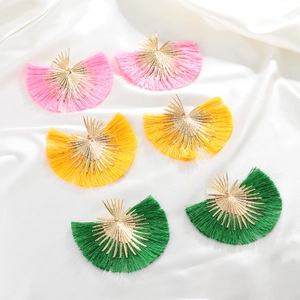 Detailed macro view of colorful silk tassel fan earrings in pink yellow and green colors