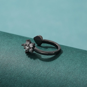 Primer plano de anillo ajustable negro con flores y circonitas blancas brillantes