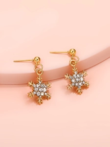 Detalle de pendientes de copo de nieve dorados con strass blancos en soporte rosa