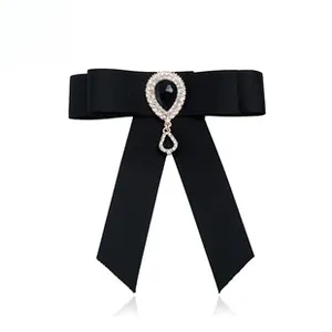 Close-up of black ribbon bow brooch with vintage crystal drop and sparkling rhinestones