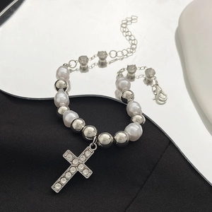 Detailed view of Baroque pearl bracelet with rhinestone cross pendant and adjustable silver chain