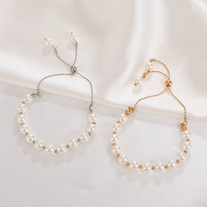 Detail of adjustable baroque pearl bracelets with gold and silver tone accents on silk