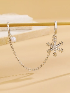 Detailed view of silver snowflake earrings with white pearls and sparkling rhinestones