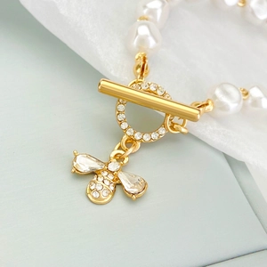 Detail of baroque pearl bracelet with gold bee pendant and T-bar clasp with rhinestones