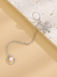 Detailed view of silver snowflake earrings with pearls and a delicate metal chain