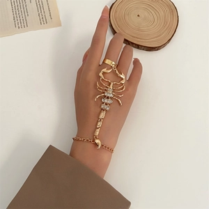 Detailed view of a gold scorpion ring-bracelet combo with sparkling rhinestones on hand