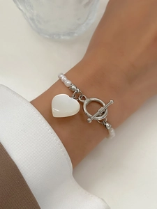 Detailed shot of Baroque pearl bracelet with heart pendant and OT toggle clasp on wrist