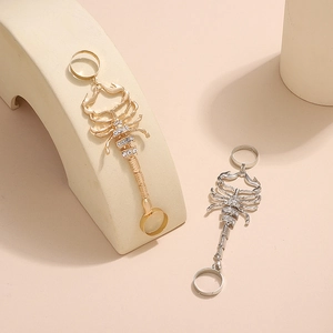 Detail of scorpion ring bracelet with white rhinestones in gold and silver finish