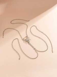 Detail of silver scorpion body chain featuring sparkling rhinestones and delicate O-links