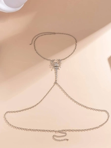 Detailed view of silver scorpion body chain with micro-set rhinestones on a cross chain link